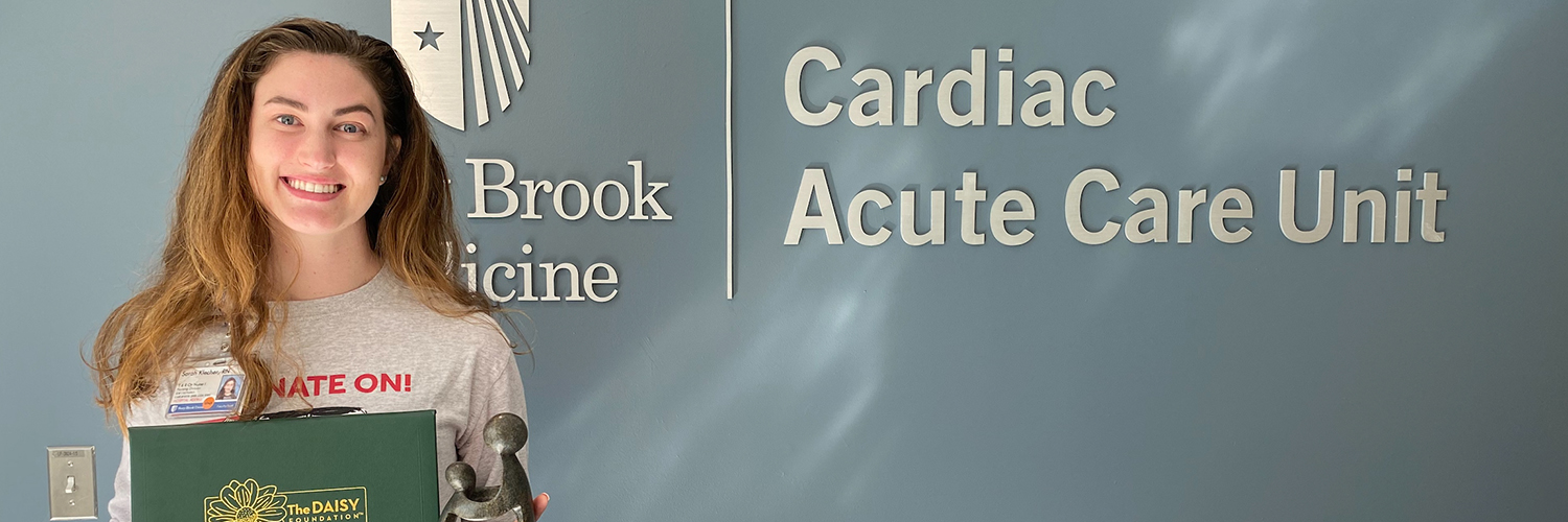 Sarah Klecher, RN, Cardiac Acute Care Unit holding DAISY award